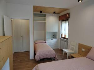 a small bedroom with two beds and a window at Casa Silva in Pieve Tesino