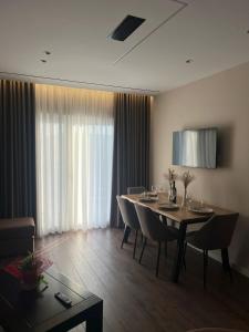 a dining room with a table and chairs and curtains at AMAD Aparthotel in Sarandë