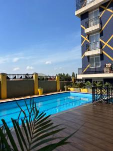 a swimming pool in front of a building at Modern 1BR Apartment with Pool & Sauna Kampala in Kira