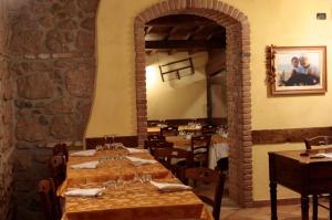 a dining room with tables and a stone wall at La Piana Dell'erika in Aprilia
