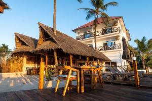 a resort with tables and chairs and a building at Dhow Beach Boutique Hotel in Nungwi