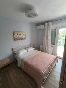 a bedroom with a bed with a pink blanket at Pine Lodge in Kavála