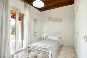 a white bedroom with a bed and a window at Villa ChrisDina in Nýmfai +42 photos
