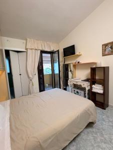 a bedroom with a large white bed and a desk at B&B Is Pranus a Mari Casa Privata in Solanas