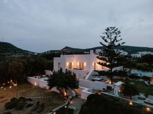 a large white building with a christmas tree in front of it at Eos Milos House in Pollonia