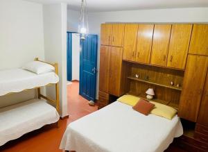 a bedroom with two beds and a blue door at Sítio São Roque in São Roque +28 photos