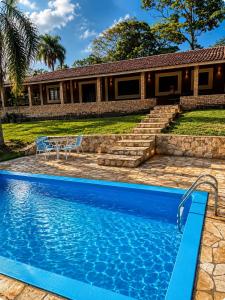 a swimming pool in front of a house at Sítio São Roque in São Roque