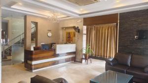 a lobby with a reception desk and a couch at Hotel Surya Palace - Durg Railway Station in Durg +15 photos