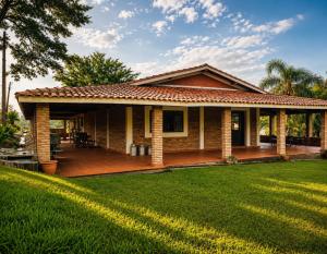a house with a deck and a lawn at Sítio São Roque in São Roque