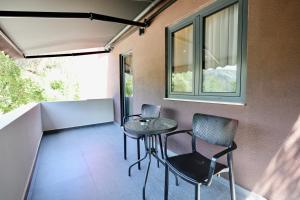a small table and chairs in a room with windows at Andorini Hotel in Finiq