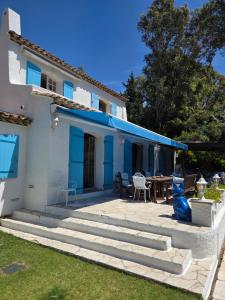 a white house with blue doors and a patio at Villa Provençal StTropez Ramatuelle Pampelonne beach in Saint-Tropez