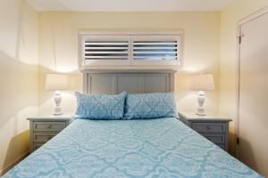 a bedroom with a blue bed with two night stands at C308B - Duck Tails in Duck
