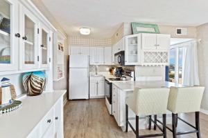 a kitchen with white cabinets and a white refrigerator at C308B - Duck Tails in Duck +30 photos