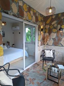 a bedroom with a bed and a glass door at Kot Ory Mountain View Studio in Moka