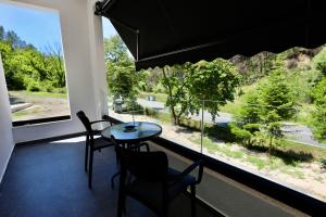 a room with a table and chairs and a large window at Andorini Hotel in Finiq