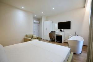 a bedroom with a bed and a bathroom with a tub at Andorini Hotel in Finiq