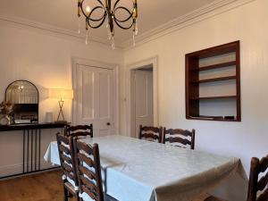 a dining room with a white table and chairs at Glenrigh House - Main Residence for 7 people in Onich