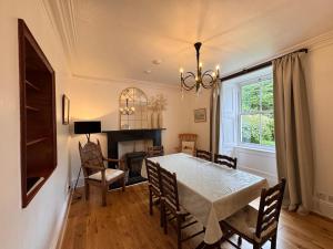 a dining room with a table and chairs and a fireplace at Glenrigh House - Main Residence for 7 people in Onich