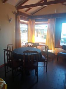 a dining room with a table and chairs and a window at Cabañas Lago Sur in Puerto Varas