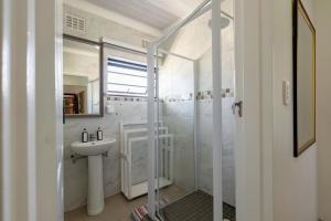 a white bathroom with a sink and a shower at Safi Elegant Self-catering Suite 5 in East London