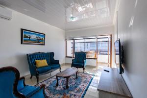 a living room with two chairs and a tv at Safi Elegant Self-catering Suite 5 in East London