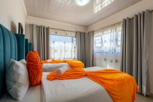 two beds in a bedroom with an orange teddy bear at Safi Elegant Self-catering Suite 5 in East London