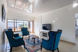 a living room with three chairs and a tv at Safi Elegant Self-catering Suite 5 in East London +4 photos