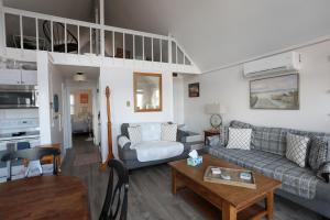 a living room with a couch and a table at Pet-Friendly Private Beach Oceanfront Cottage in Charlestown