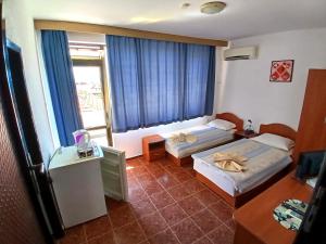 a hotel room with two beds and a window at Guest House Olimpiya in Sveti Vlas +66 photos
