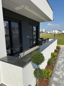 a house with a balcony with a table and chairs at Apartments Lialda in Donji Štoj +6 photos