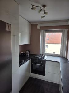 a small kitchen with a stove and a window at Apartament Górna in Głuszyca