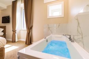 a bathroom with a tub with blue water in it at Live in Gaeta in Gaeta