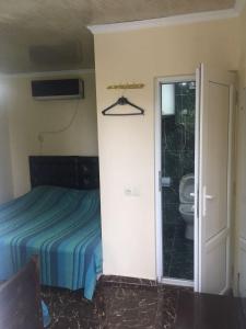 a bedroom with a bed and a bathroom with a toilet at KARTSIVADZe in Ureki