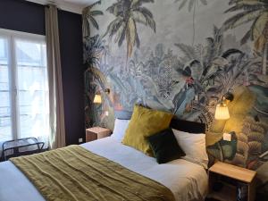 a bedroom with a large bed with a tropical wallpaper at Hotel Du Cygne Tours in Tours
