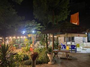 a patio with a table and an umbrella at night at KARTSIVADZe in Ureki