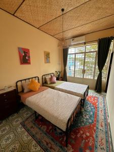 a bedroom with two beds and a large window at The Mê Linh House in Nha Trang
