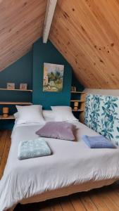 a large bed in a room with blue walls at La Bonne Etoile, près Giverny in Vernon