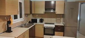 a small kitchen with a sink and a refrigerator at Relaxing home 80m from the sea in Perea
