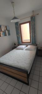 a bed in a room with a window at Le Thalassa I appartement T2 en bord de plage et du Port in Gruissan +8 photos