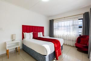 a bedroom with a large bed and a red headboard at Safi Luxury Apartment 6 - 2 bedroom in East London
