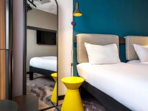 a hotel room with a bed and a mirror at Hotel Ibis Krakow Centrum in Krakow