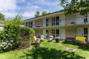 un edificio de apartamentos con un patio con sillas y mesas en Baurs Park, en Hamburgo