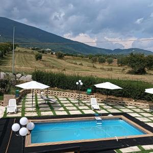 a swimming pool with two chairs and umbrellas at Villa Beregra in Lempa