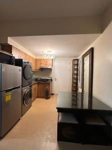 a kitchen with a stainless steel refrigerator and a stove at Juja's place in Manila