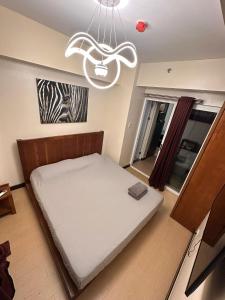 a bedroom with a bed and a chandelier at Juja's place in Manila +74 photos