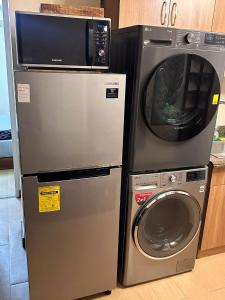 a refrigerator and a microwave next to a washing machine at Juja's place in Manila