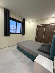 a bedroom with a large bed and a window at Marina smir Oceanica Apartments in Marina Smir