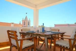 a wooden table and chairs on a balcony at Casa C Alcoutim in Alcoutim