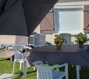 a table with chairs and a blue table umbrella at location pour 24h du mans in Arnage