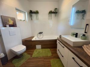 a bathroom with a sink and a toilet and a tub at Puzzle Haus in Gyenesdiás